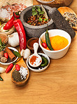 Food, mortar and spices on table top for cooking gourmet meal, chili seasoning or flavor pestle. Pepper vegetables, kitchen condiments and variety of plant herbs for brunch, healthy diet or vitamins.