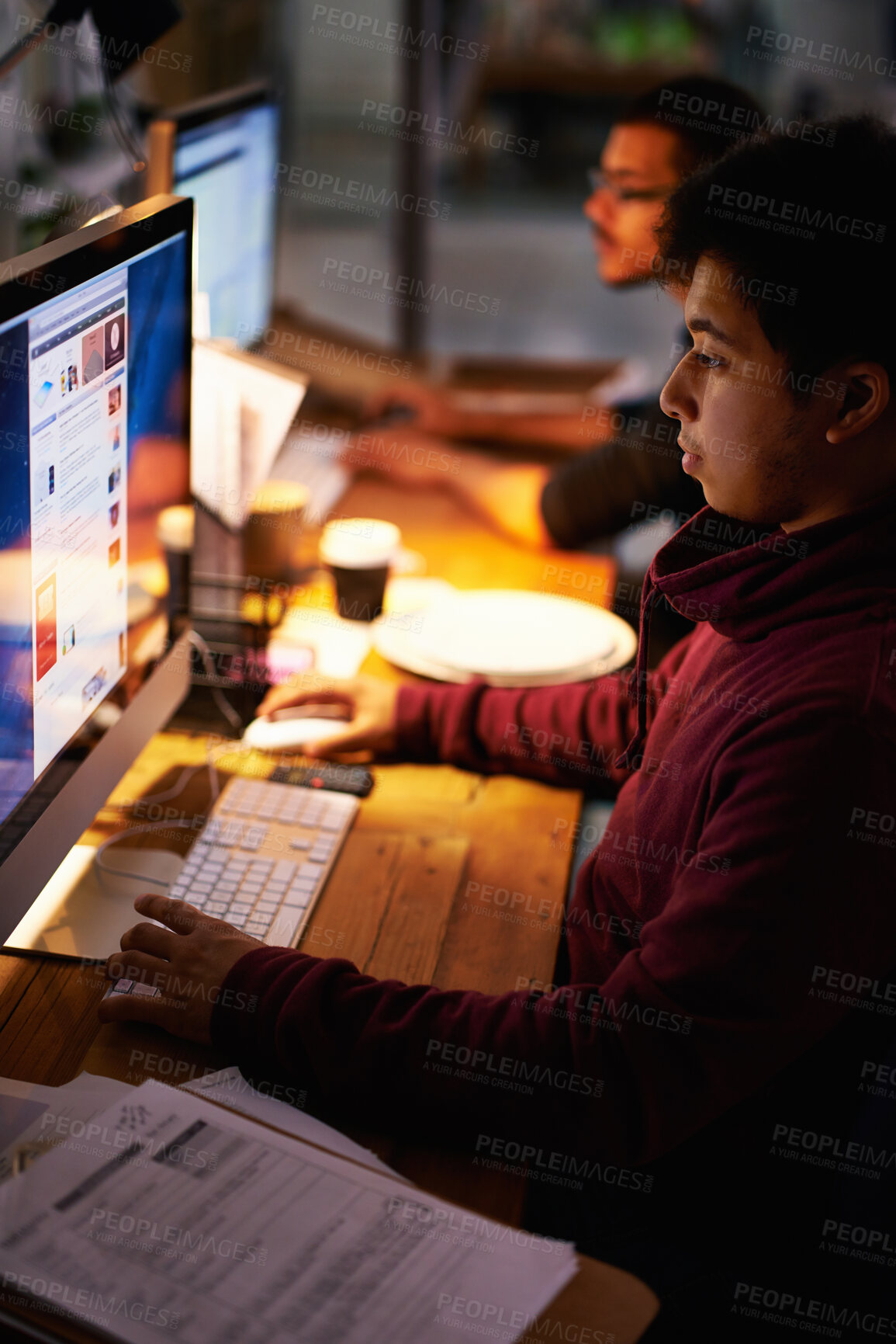 Buy stock photo Cropped shot of a group of young coworkers working in a dimly-lit office