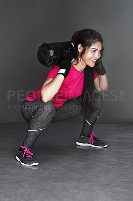 Buy stock photo Woman, workout and sandbag squats for training glutes or muscle growth for challenge, fitness or weightlifting. Female person, studio and equipment for strength performance, grey background or goals