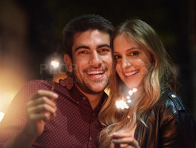 Buy stock photo Portrait, happy couple and sparklers at night for party, celebration and event together outdoor in city with light. Face, man and woman with fireworks on holiday, romantic date or laugh on vacation