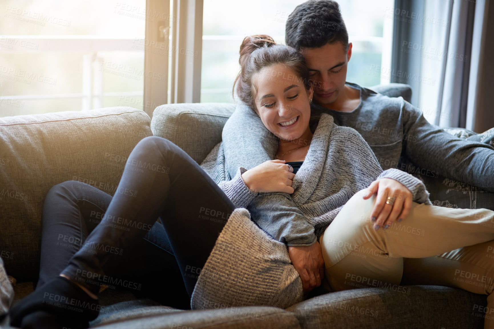 Buy stock photo Couple, hug and couch for relax and love, calm and support in home for weekend. Cozy, happy and smile for man and female person for cuddle and living room, romance or sofa in lounge for dating people