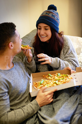 Buy stock photo Man, woman and pizza on couch for eating, nutrition and fast food together in apartment with smile. Couple, meal and happiness with love on sofa for dinner, weekend and hungry people in London 