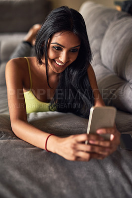 Buy stock photo Selfie, woman and lying on sofa with smartphone for photo, profile picture or social media update in living room. Indian, smile and person with mobile for internet post, networking or memory in home