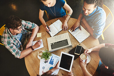 Buy stock photo High angle shot of a group of students studying in a coffee shop