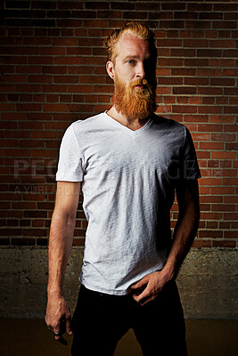 Buy stock photo Man, portrait and confident clothing by brick wall, pride and tattoo or shirt in outdoor. Male person, serious face and gen z or casual outfit for aesthetic, designer fashion and weekend travel