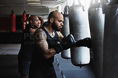 Buy stock photo Hit, punching bag and man in boxing class for workout, challenge or competition training. Power, muscle and champion boxer in exercise with confidence, fitness gym and energy in MMA sports club.