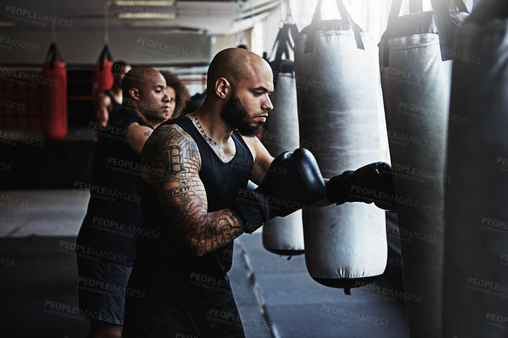 Buy stock photo Hit, punching bag and man in boxing class for workout, challenge or competition training. Power, muscle and champion boxer in exercise with confidence, fitness gym and energy in MMA sports club.