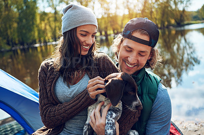 Buy stock photo Dog, camping or couple on adventure with love of animal for freedom in nature, sunshine or smile at lake, travel or holiday. Happy, woman or man with puppy pet to care, hug or relax on summer journey