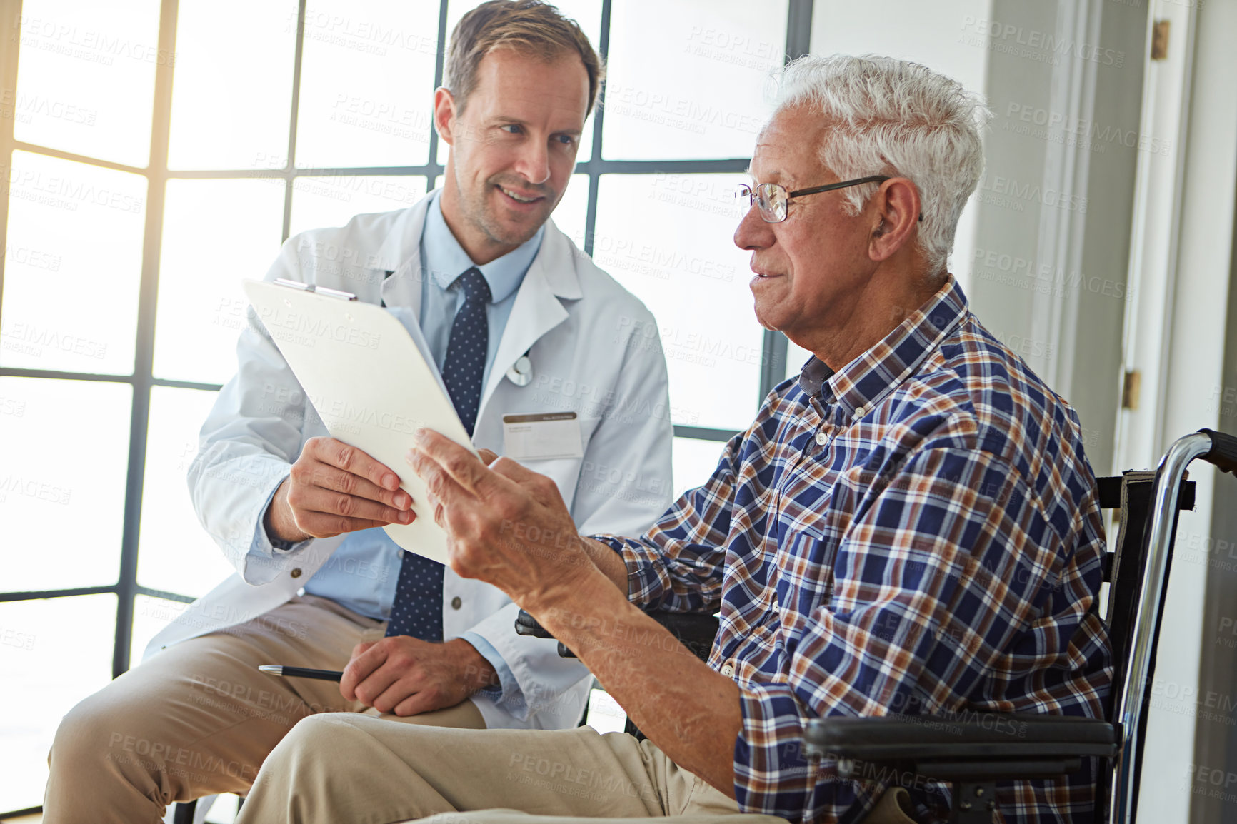 Buy stock photo Doctor, man and wheelchair with paperwork for consultation, report or medical review in hospital. Medic, clipboard and person with disability in clinic for documents, check or rehabilitation for care