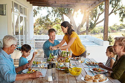 Buy stock photo Happy family, eating and food with relax outdoor on patio with conversation, bonding and healthy meal in summer. Parents, grandparents and kids at dining table in backyard of home with talking or fun