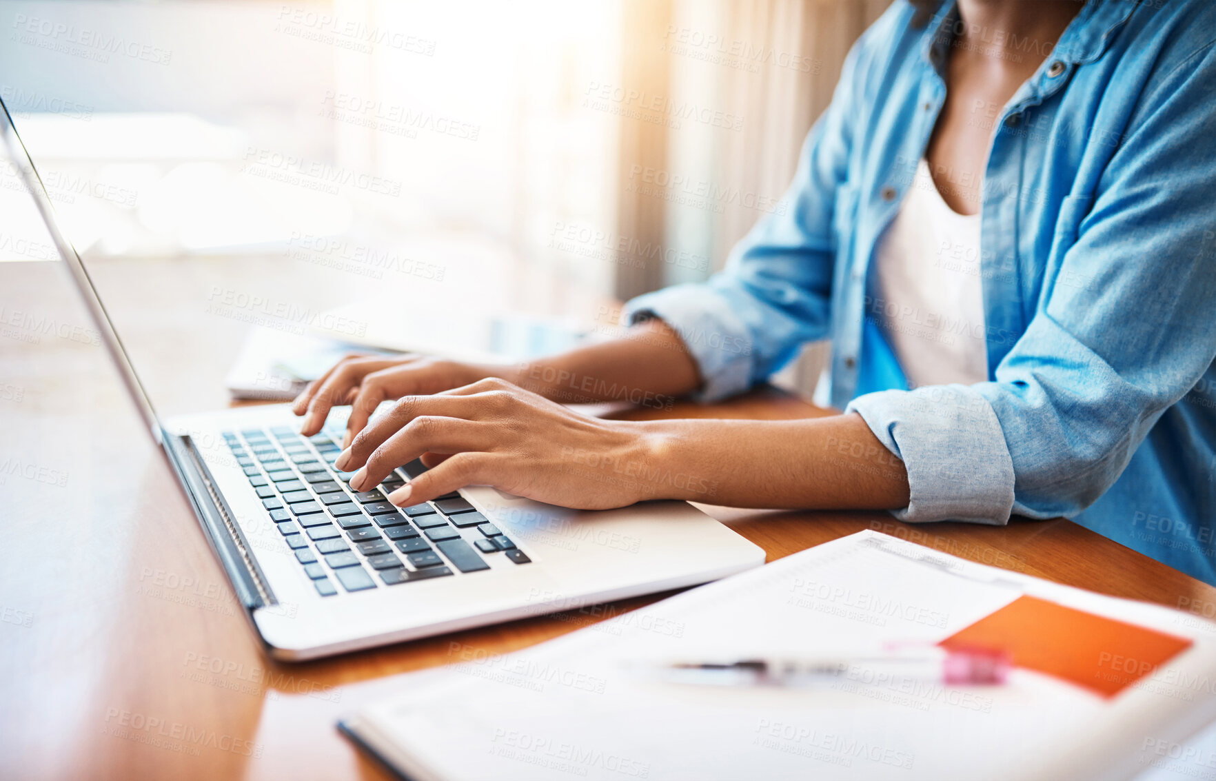 Buy stock photo Shot of an unrecognizable young woman working on her laptop at home