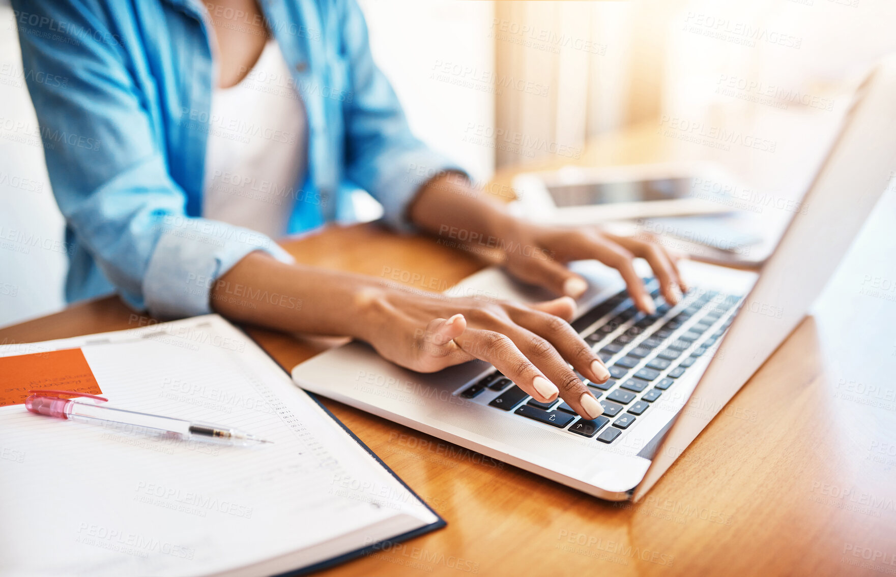 Buy stock photo Shot of an unrecognizable young woman working on her laptop at home