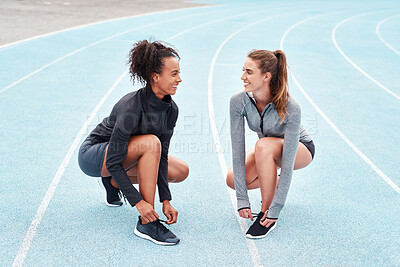 Buy stock photo Sports, women and race track in smile with sportswear for training, outdoor or workout in stadium for wellness. Female athletes, shoes and break in exercise for tournament, competition or contest