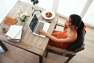 Buy stock photo High angle shot of an attractive young businesswoman sitting in her office and using her laptop while on a call