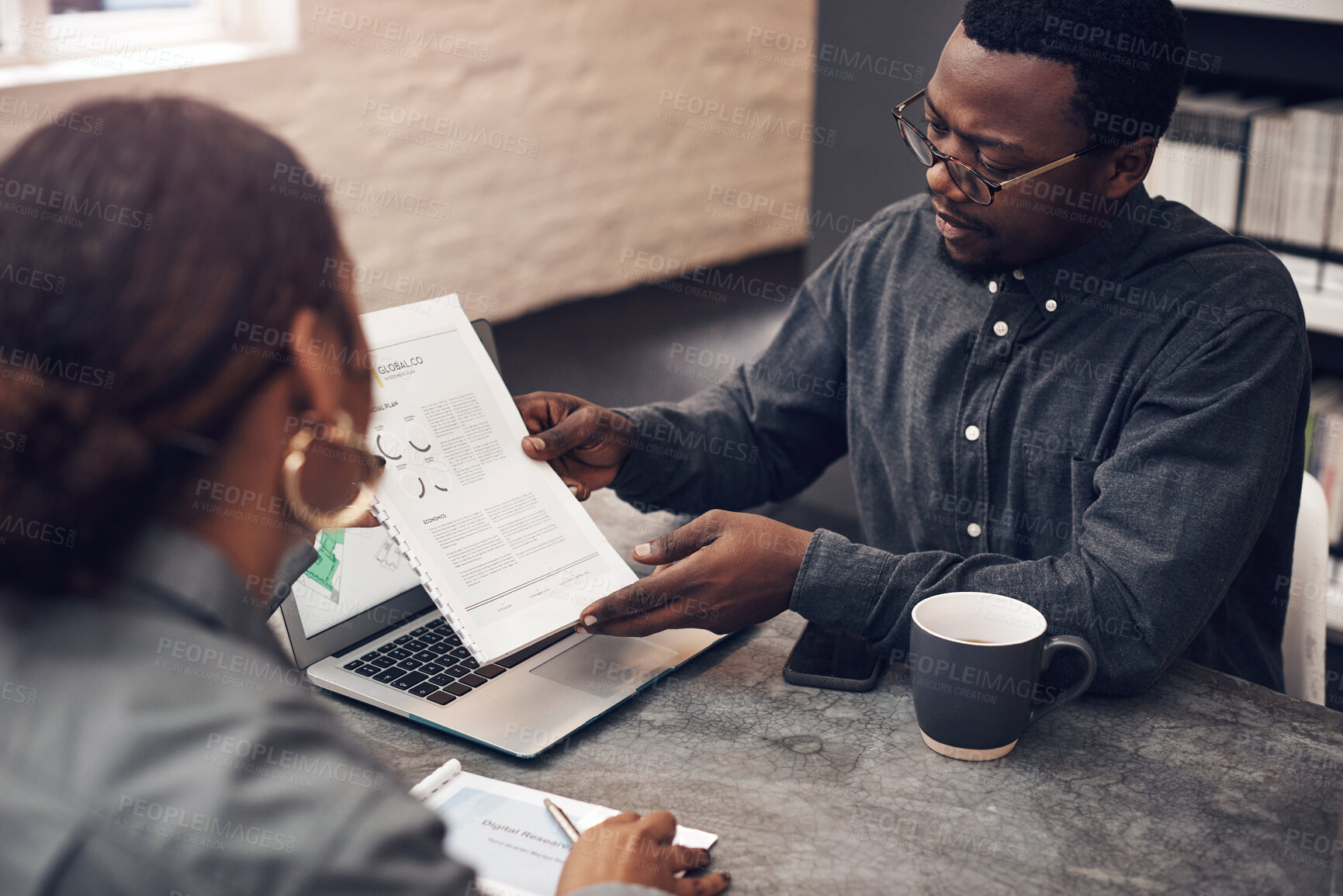 Buy stock photo Cropped shot of a handsome young male architect having a discussion with his colleague in a modern office