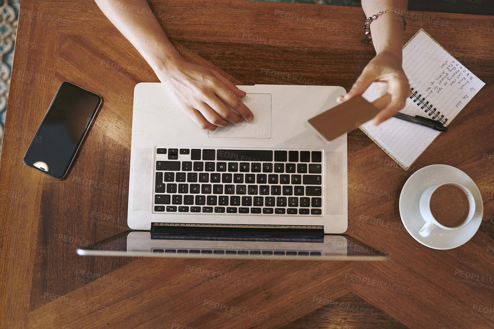 Buy stock photo High angle shot of a woman using a laptop and credit card while working at a cafe