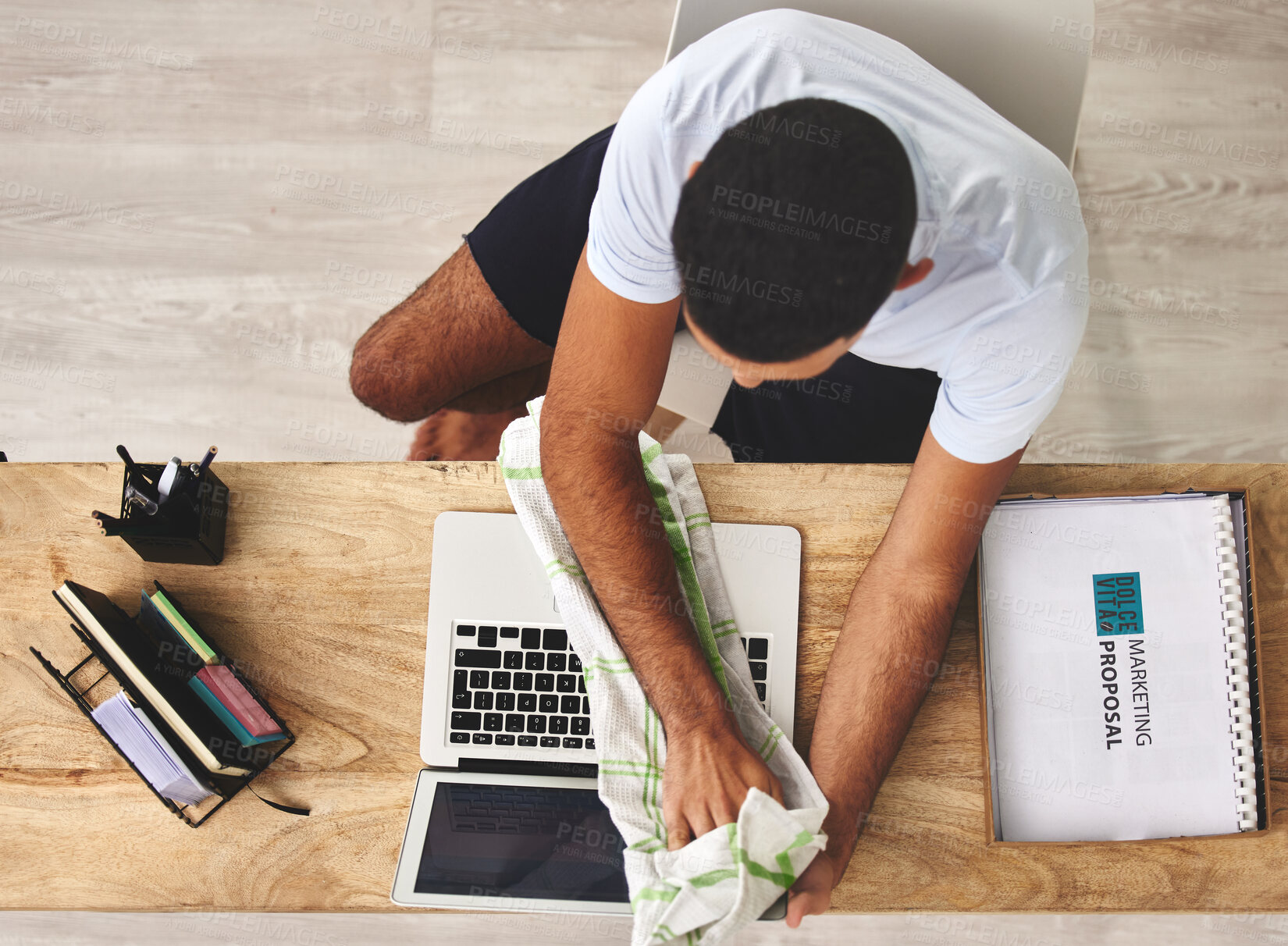 Buy stock photo Remote work, home and man with cleaning of laptop on desk for hygiene, maintenance and dust. Cloth, wipe and creative person with technology for marketing proposal, research and safety from above