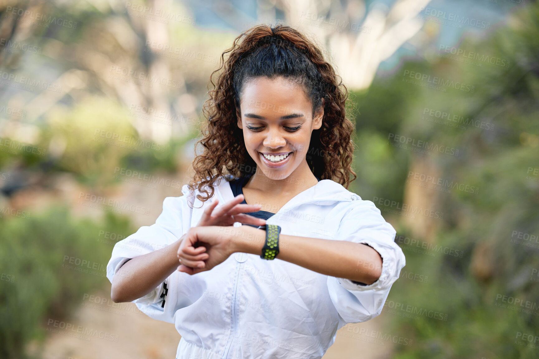 Buy stock photo Shot of a young woman checking her running time on her smart watch