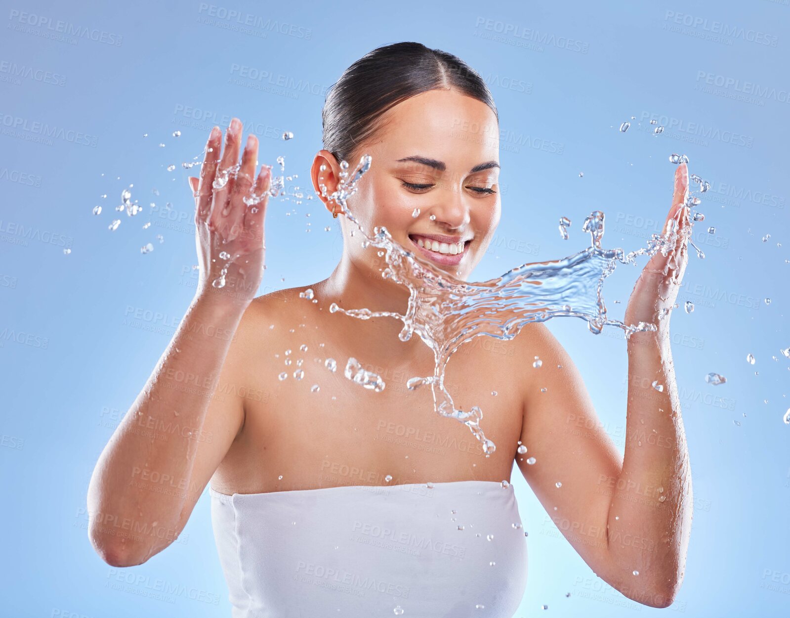 Buy stock photo Hydration, face wash and happy woman in studio for facial, clear skin and rejuvenate on blue background. Skincare, water splash and smiling girl for cleaning with refresh, wellness and freshness