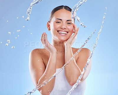 Buy stock photo Water splash, hydration and happy woman in studio for portrait, clear skin and rejuvenate on blue background. Skincare, facial and girl for cleaning with refresh, sustainable wellness and freshness