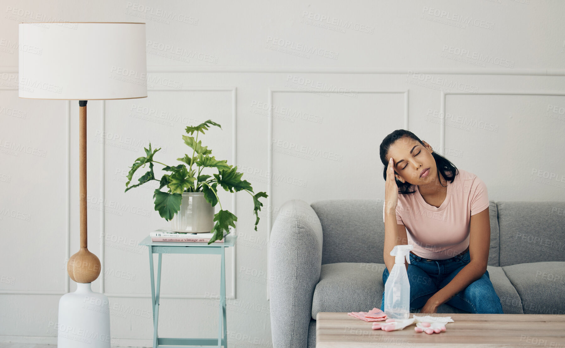 Buy stock photo Shot of a woman looking stressed while busy cleaning at home