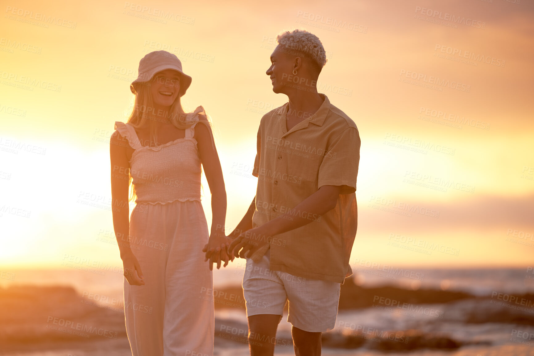 Buy stock photo Love, sunset and couple holding hands at beach for tropical holiday adventure, relax and bonding together. Evening, happy man and woman on romantic date with ocean, sky or walking on outdoor vacation