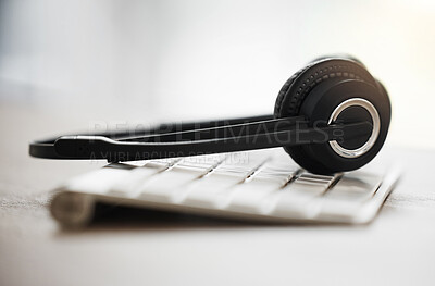 Buy stock photo Headphones, keyboard and call center with equipment on desk for customer service, support or hotline. Closeup of headset, mic or technology in empty workplace for telemarketing, online advice or help