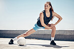 Sports, fitness and football woman stretching on a city building rooftop with a ball feeling fit, healthy and motivated. Workout, exercise and urban girl training doing warm up for soccer in England