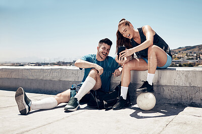 Buy stock photo Soccer training, phone and friends happy on video call or laugh at social media outdoors. Fitness man, athlete woman and relax after lifestyle workout chat on tech communication in city