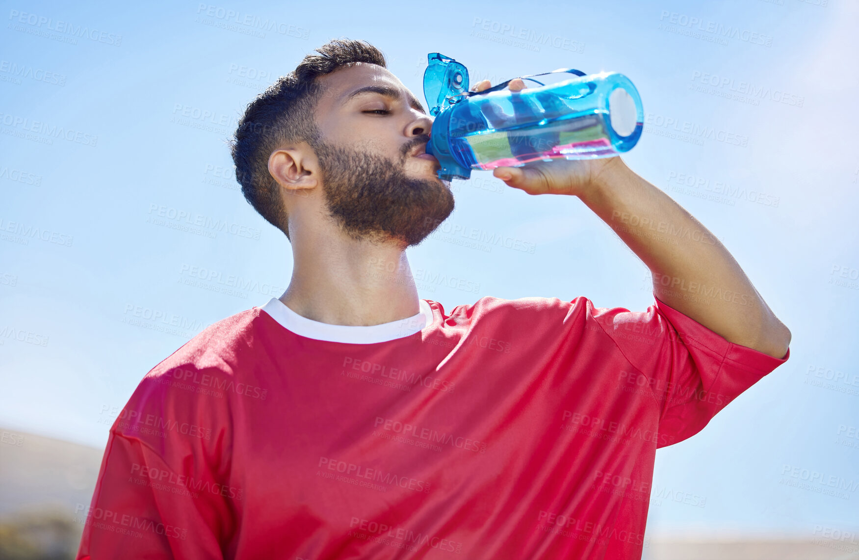 Buy stock photo Sports, fitness and drinking water with man in sunshine and blue sky mock up for outdoor wellness, training and healthy lifestyle. Tired athlete with water bottle for workout, exercise or practice