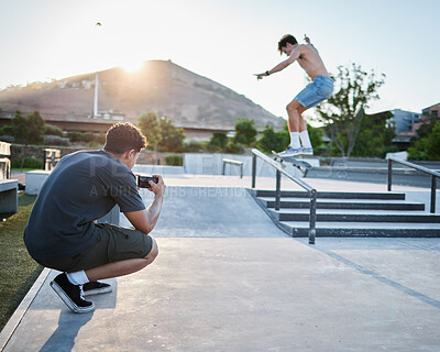 Buy stock photo Skateboard jump outdoor, photographer in park for extreme sports photoshoot with skater in summer. Skatepark photo session, man grind rail and sport for fitness, stunt and training in Cape Town