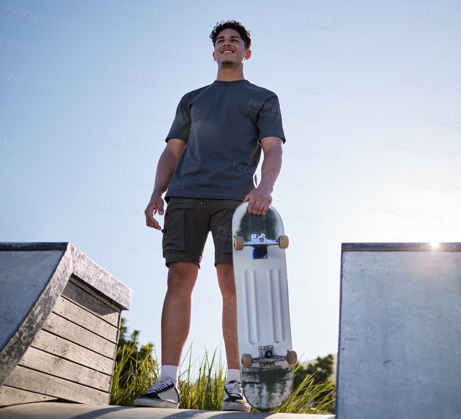 Buy stock photo Skateboard, sports and man on ramp at community skate park for freedom, exercise and fitness with smile and thinking about goal, motivation and dream. Happy skater male outdoor for fun and adventure