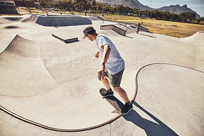 Buy stock photo Skater, sports and man at skate park in city performing action trick or stunt. Fitness, skateboarding and young male skateboarder on ramp training, practice or workout outdoors in town for exercise.
