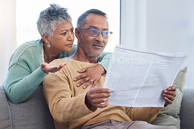 Buy stock photo Senior couple, shocked and surprised by news while reading newspaper on sofa in living room at home together. Old man and woman check media article with fake news or bad crisis headline in retirement