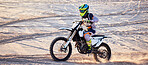 Motorcycle, desert race and extreme sport expert with agile speed, power or balance in nature. Motorbike man, rally and sand on fast vehicle with helmet, safety clothes and motivation for motorsport