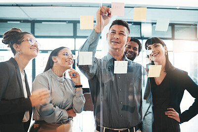 Buy stock photo Business people, writing and planning schedule, brainstorming or strategy on glass wall at office. Group of employee workers in team project plan, tasks and write sticky note together