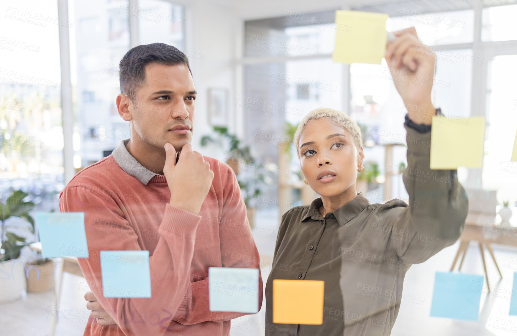 Buy stock photo Creative people, planning and thinking for schedule, team strategy or brainstorming on glass wall at office. Man and woman in teamwork contemplating plan, tasks and sticky note or startup