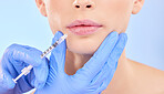 Injection, woman and lips with plastic surgeon for beauty and hands in studio with blue background. Face, syringe and doctor for injecting mouth with collagen or filler and implants.