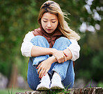 Student, sad and thinking with woman in park for depression, college and anxiety. Mental health, psychology and burnout with Asian person feeling lonely in nature for fatigue, pain and problem