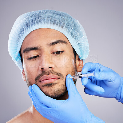 Buy stock photo Hands, face and plastic surgery with a man in studio on a gray background for injection. Needle, beauty and transformation with a male customer in a clinic for antiaging filler or cosmetics