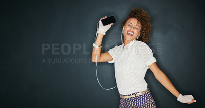 Buy stock photo Woman, energy and dancing with smartphone, earphones for music and happiness isolated on chalkboard background. Excited, moving and listen to radio playlist for fun, mockup space and audio with joy