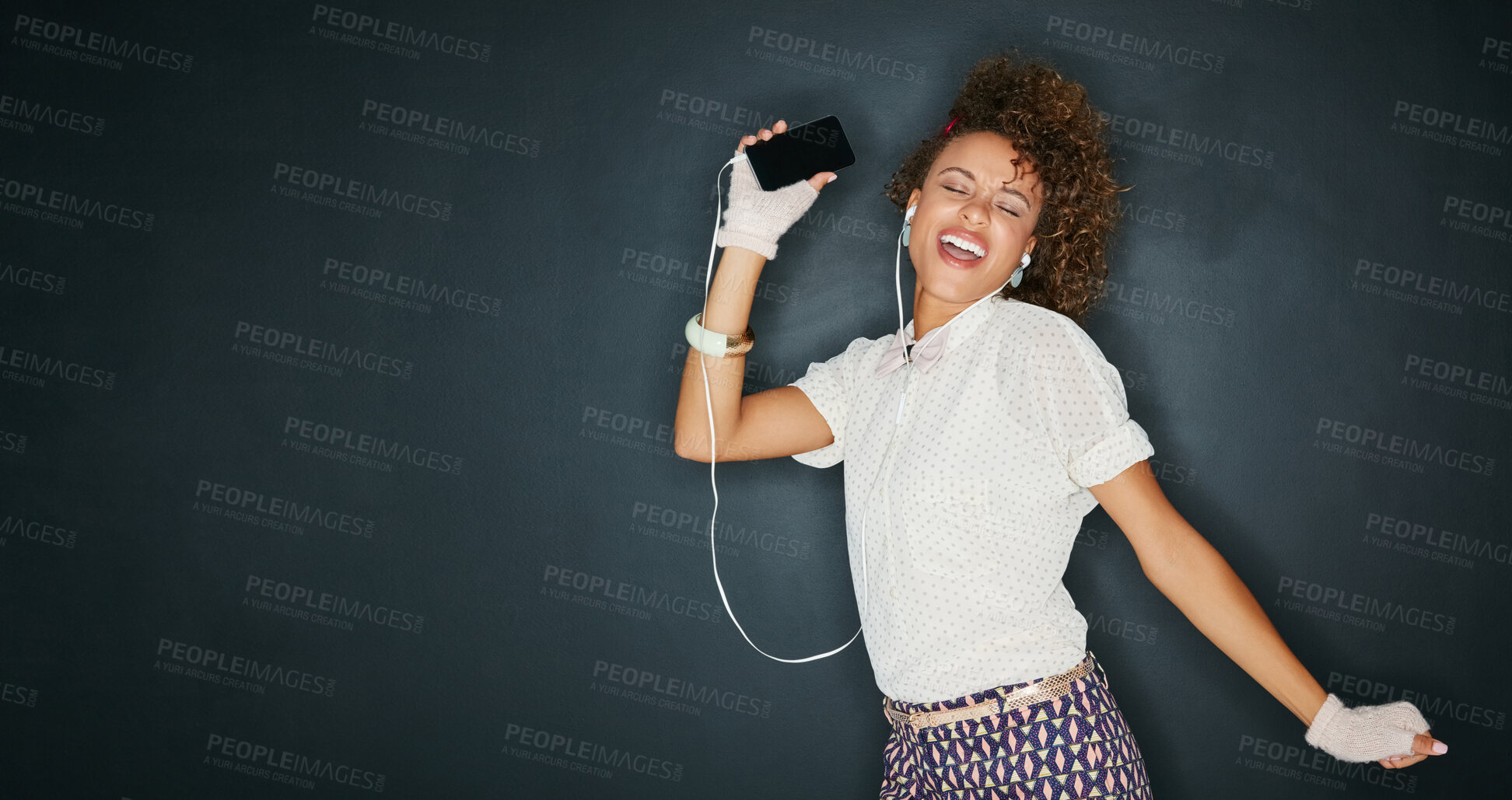 Buy stock photo Woman, energy and dancing with smartphone, earphones for music and happiness isolated on chalkboard background. Excited, moving and listen to radio playlist for fun, mockup space and audio with joy