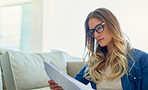 Woman, planning and reading paper on sofa for application form, contract review and financial investment for insurance. Girl, documents and serious in home for paperwork, survey and remote work.