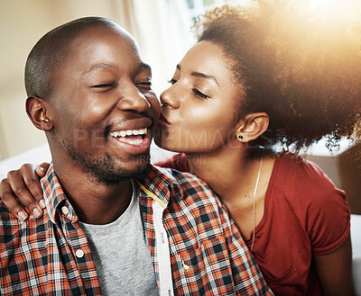 Kiss, love and black couple on sofa in new home with affection, marriage and mortgage. Smile, happy man and woman on couch with romantic embrace, property investment and excited together in house.