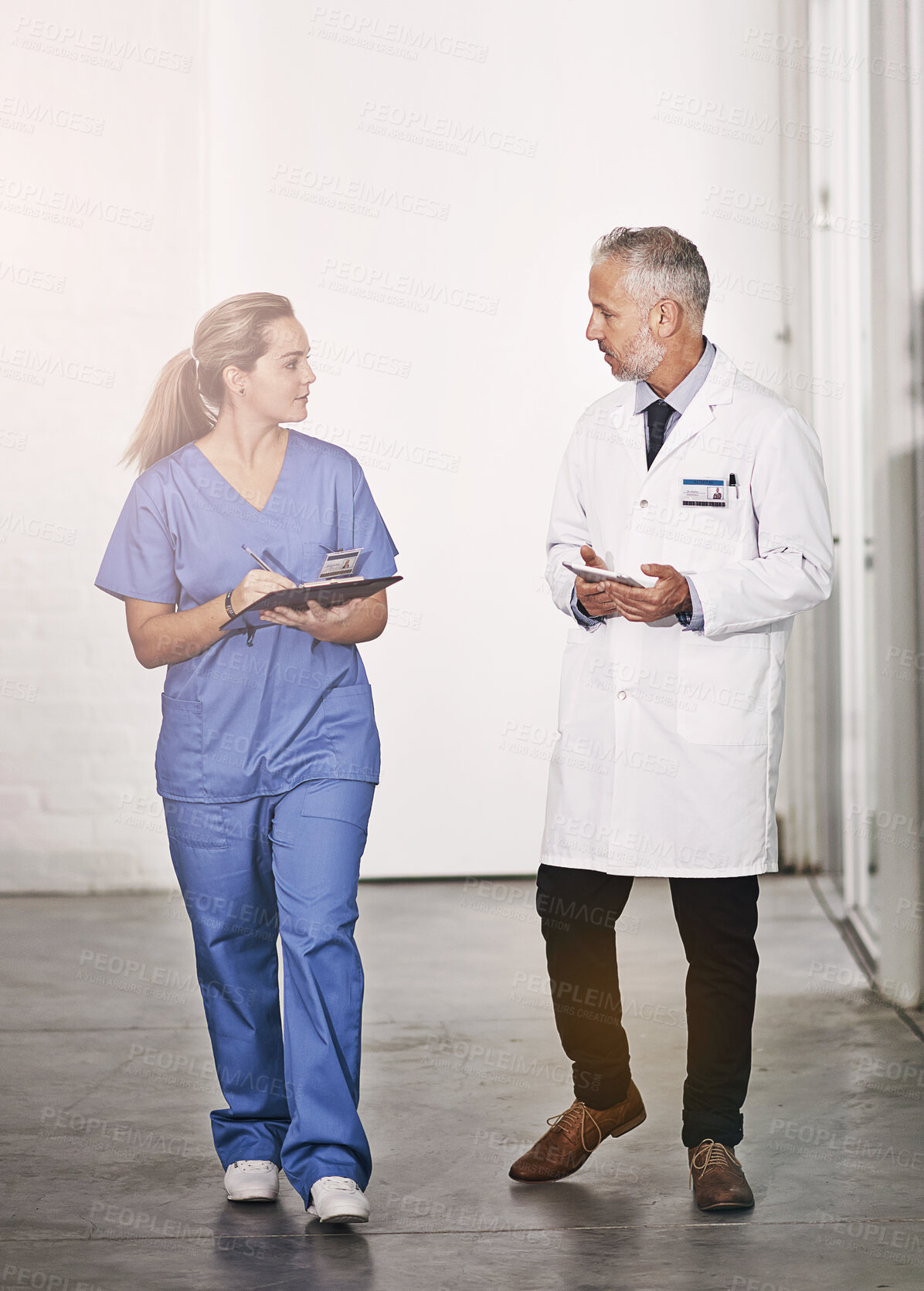 Buy stock photo Doctor, man and woman with writing for internship, advice and teaching in hospital hallway. People, mature medic and mentorship for healthcare service with checklist, notes and information in clinic