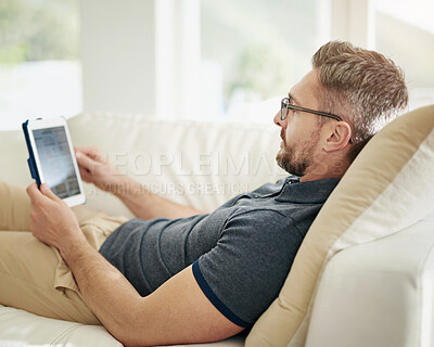 Buy stock photo Digital, screen and man relax on a sofa with social media, search or internet, scroll and streaming subscription at home. Tablet, ecommerce and living room with online shopping, app or menu choice