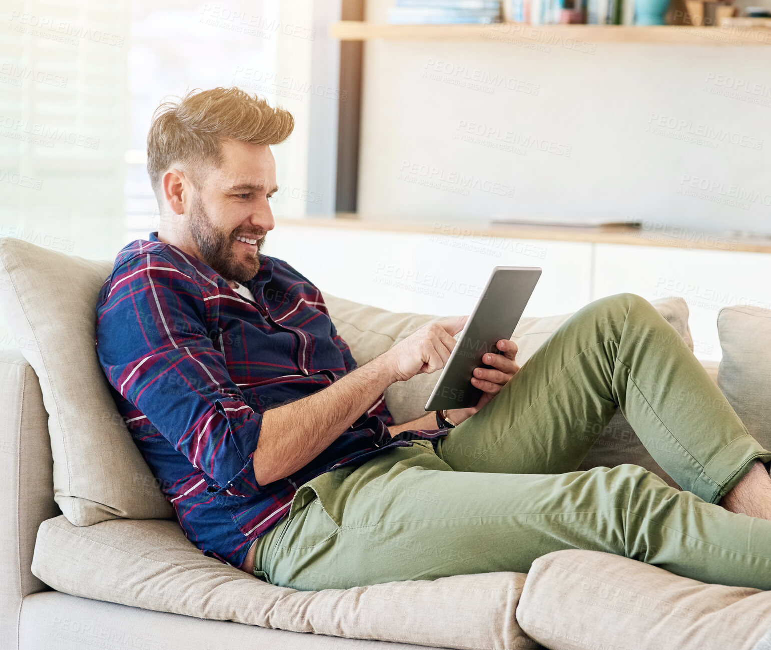 Buy stock photo Tablet, search and happy man relax on a sofa for social media, ebook or streaming video at home. Digital, smile and person in living room with ecommerce sale notification, service or app sign up