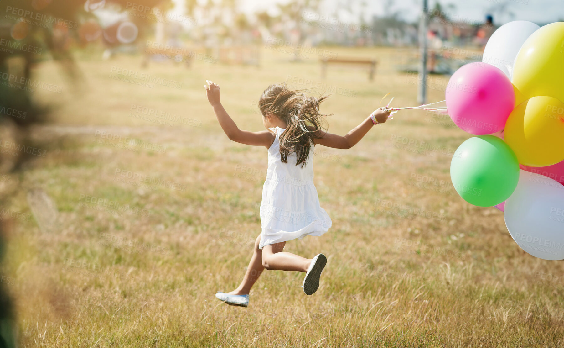 Buy stock photo Happy, girl and running in field with balloons from carnival, market and festival for success, celebrate or playing. Active, child and jump in summer with energy, inspiration and birthday party