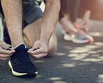 Fitness, people and tie shoes ready for workout, exercise and training for physical strength. Runners, sneakers and hands fixing laces on ground, road and athletes prepare for running or sports