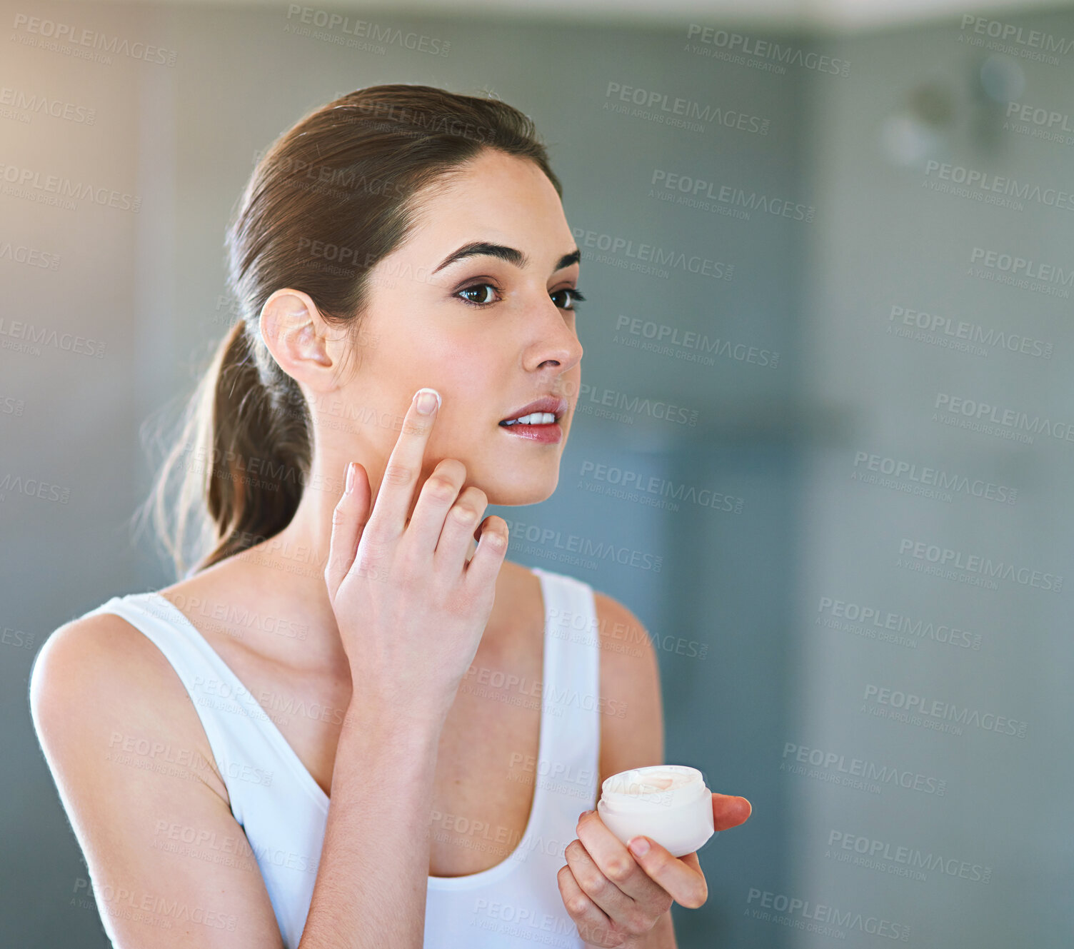 Buy stock photo Skincare, bathroom and woman with face cream application in house for wellness, shine or dermatology treatment. Beauty, product and girl with sunscreen, moisturiser or lotion at home for glowing skin